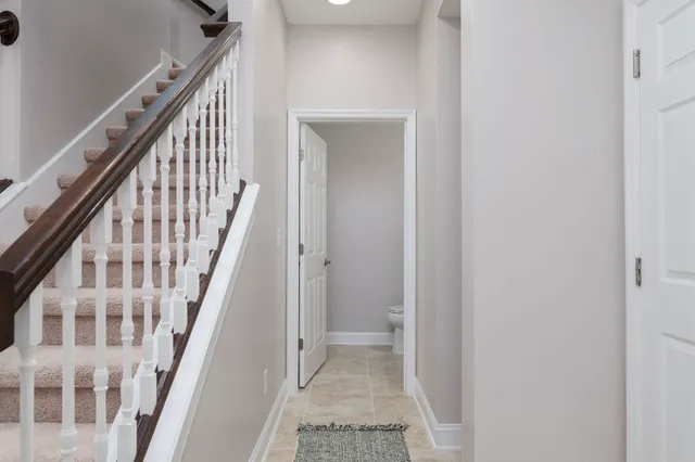 a view of staircase with wooden floor and white walls