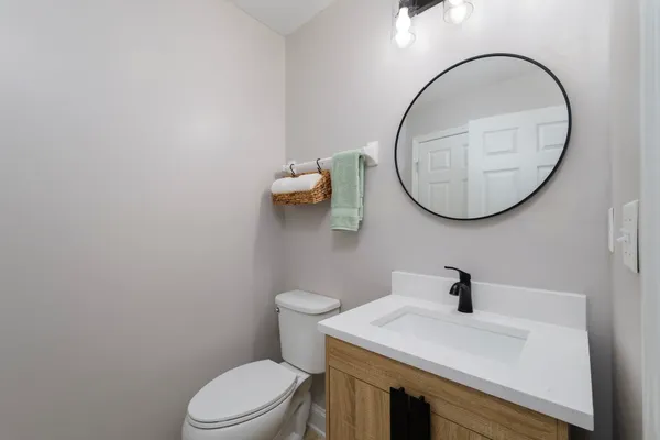 a bathroom with a sink a toilet and a mirror