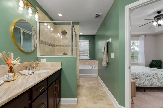 a en suite bathroom with a granite countertop sink and a mirror
