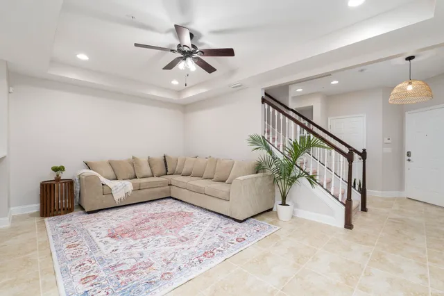 a living room with furniture and a ceiling fan