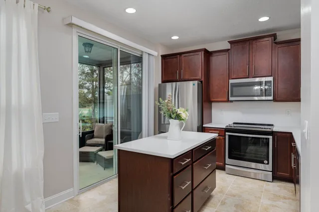 a kitchen with kitchen island granite countertop a stove and a sink