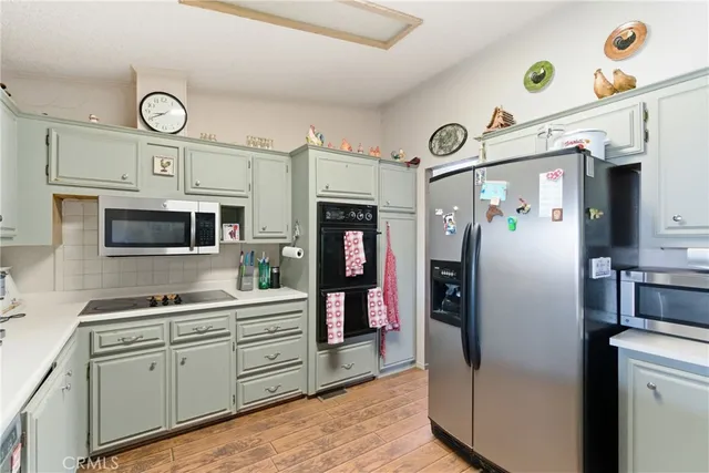 a kitchen with cabinets stainless steel appliances and a window