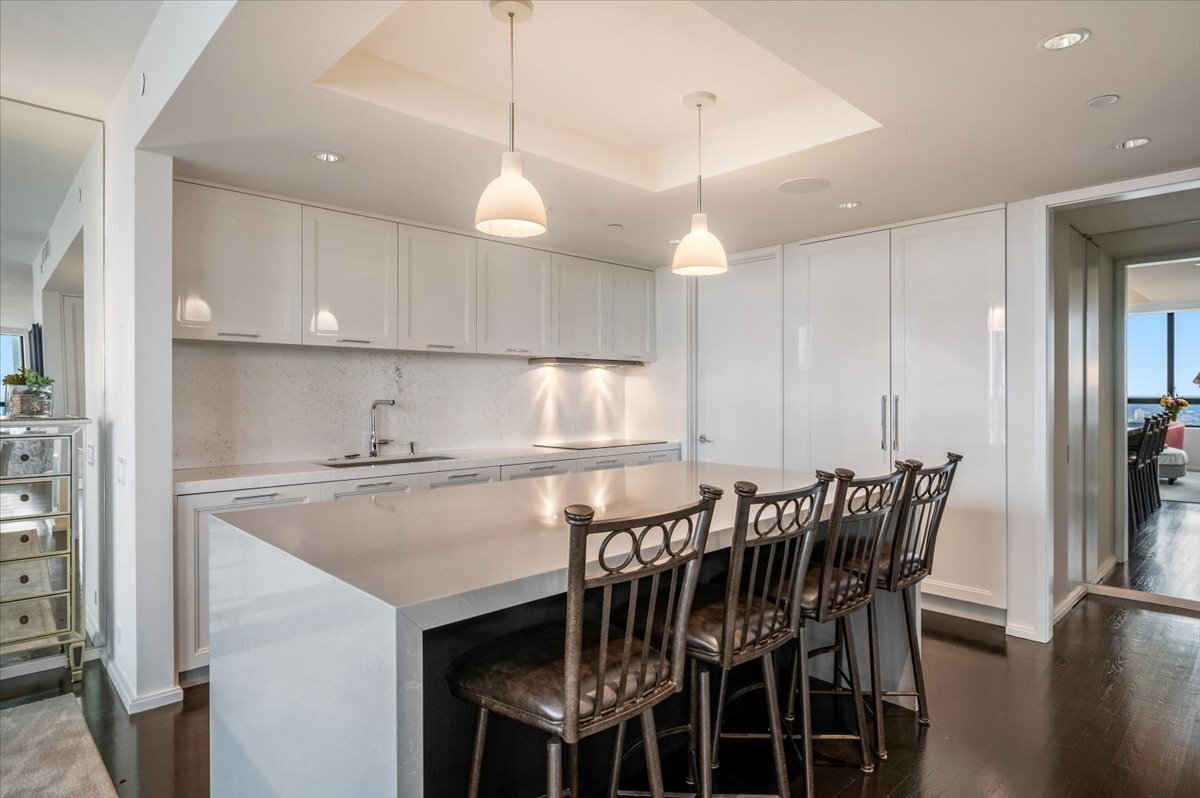 180 East Pearson Street, Unit 5107 Chicago, IL 60611 - Photo 14 of 42 a kitchen with kitchen island granite countertop a table chairs sink and cabinets