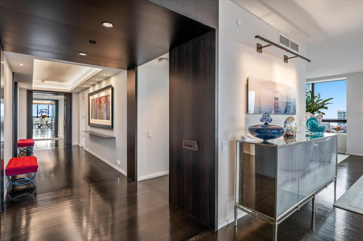 180 East Pearson Street, Unit 5107 Chicago, IL 60611 - Photo 20 of 42 a hallway with a dining table chairs and couches with wooden floor