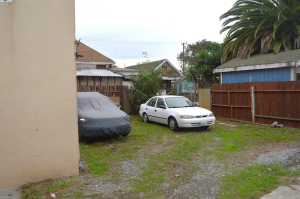 a front view of a house with a garden and parking space
