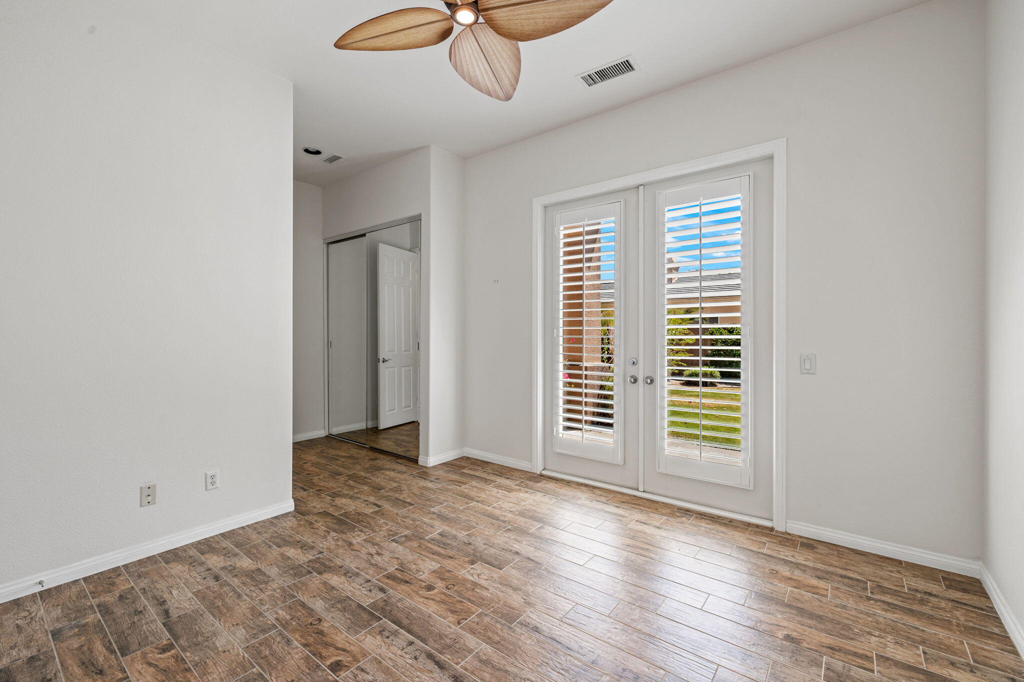 32 Calais Circle Rancho Mirage, CA 92270 - Photo 30 of 56 an empty room with wooden floor and windows