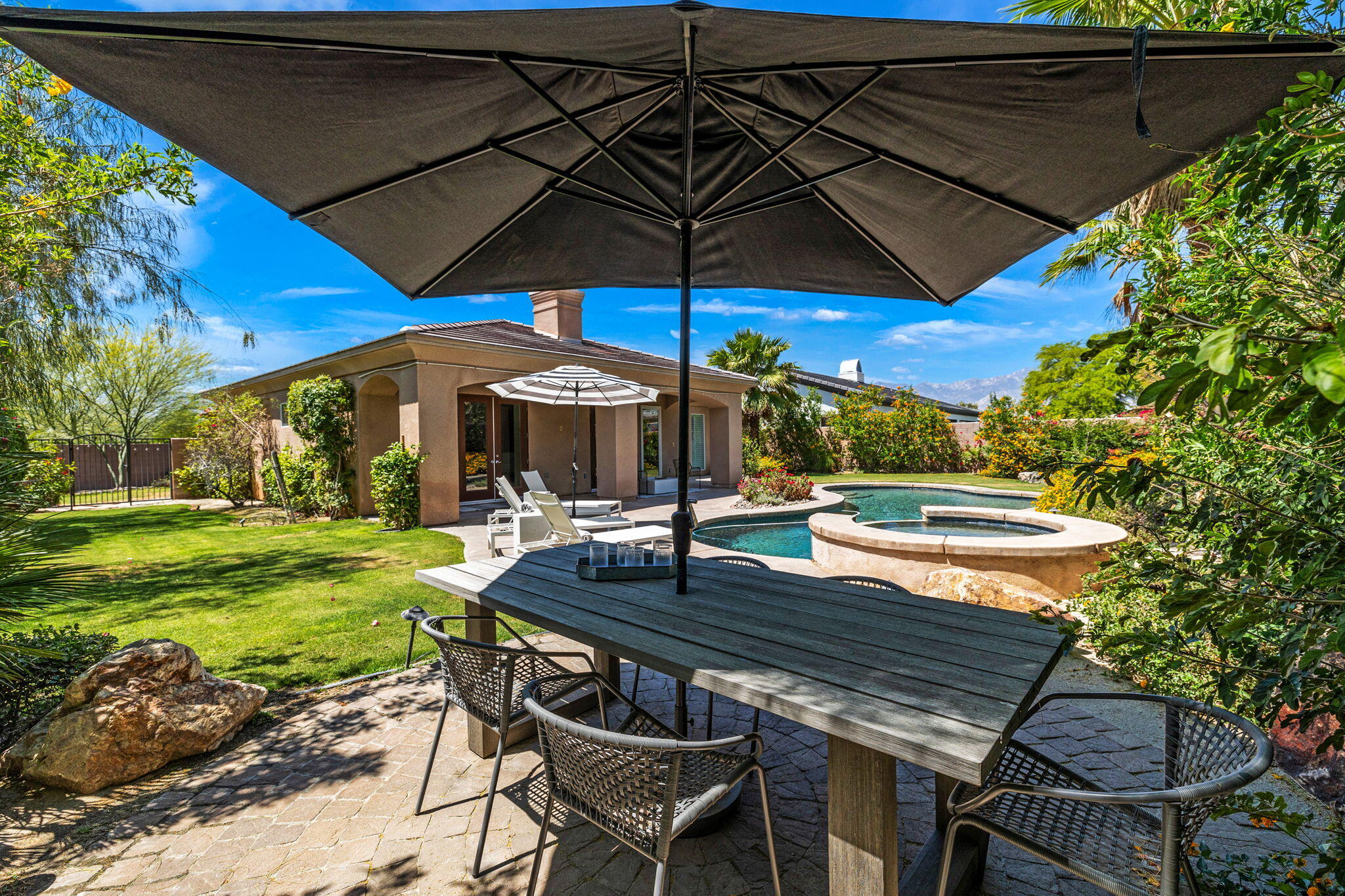 32 Calais Circle Rancho Mirage, CA 92270 - Photo 50 of 56 a patio with a table and chairs under an umbrella