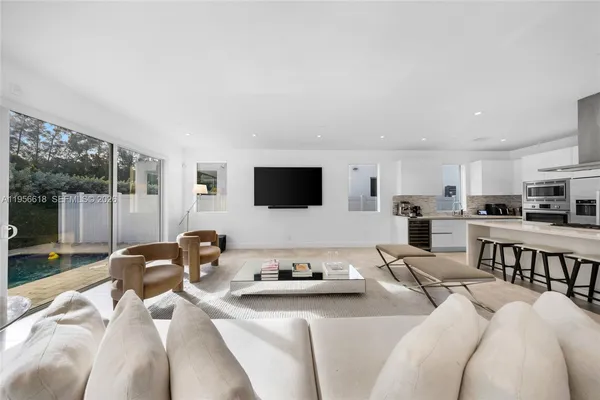 a living room with furniture a flat screen tv and a view of kitchen