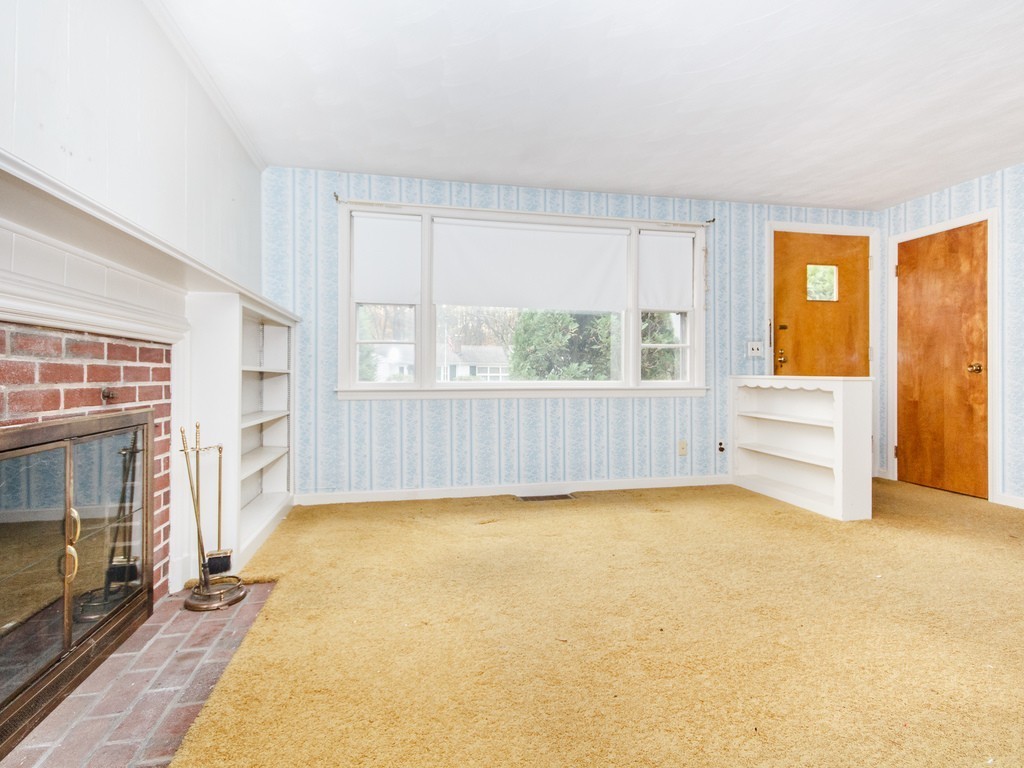 3 Trickett Road Lynnfield, MA 01940 - Photo 4 of 24 a view of an empty room with a fireplace and a window