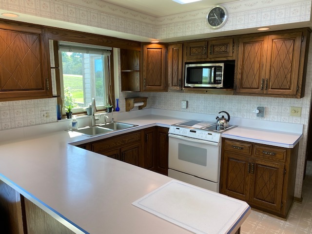 19720 Hebron Road Harvard, IL 60033 - Photo 22 of 41 a kitchen with a sink dishwasher a stove and a microwave oven with cabinets