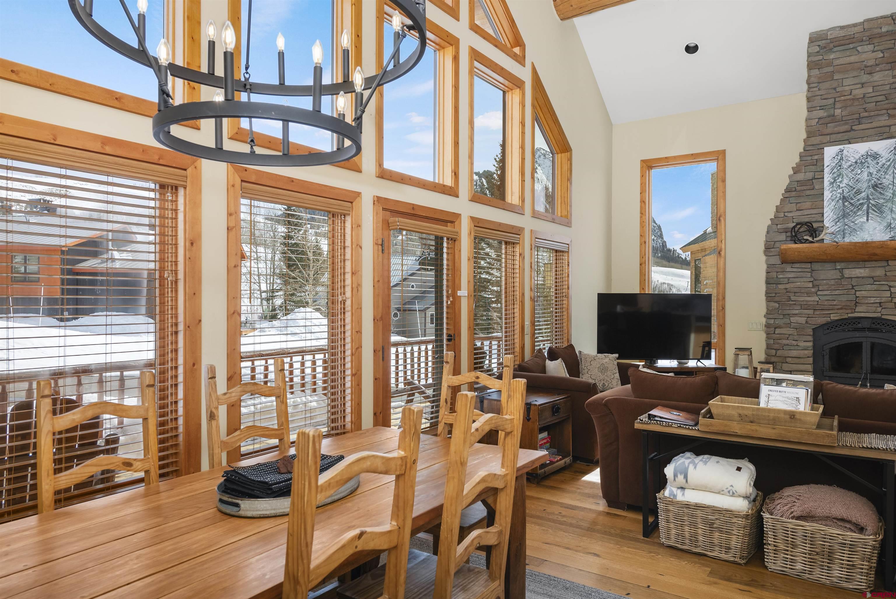 720 Gothic Road, Unit 3 Crested Butte, CO 81225 - Photo 3 of 29 a living room with furniture a fireplace and a floor to ceiling window