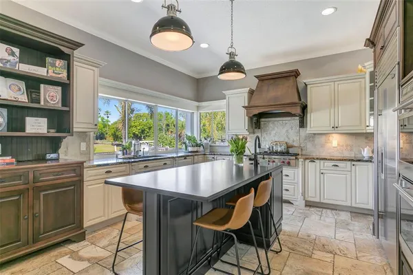 a kitchen with stainless steel appliances granite countertop a sink a stove and a refrigerator