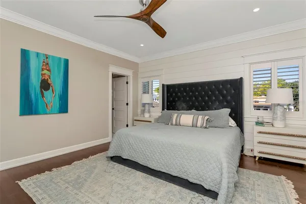 a bed sitting in a spacious bedroom next to a window