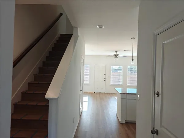 a view of a hallway with wooden floor and staircase