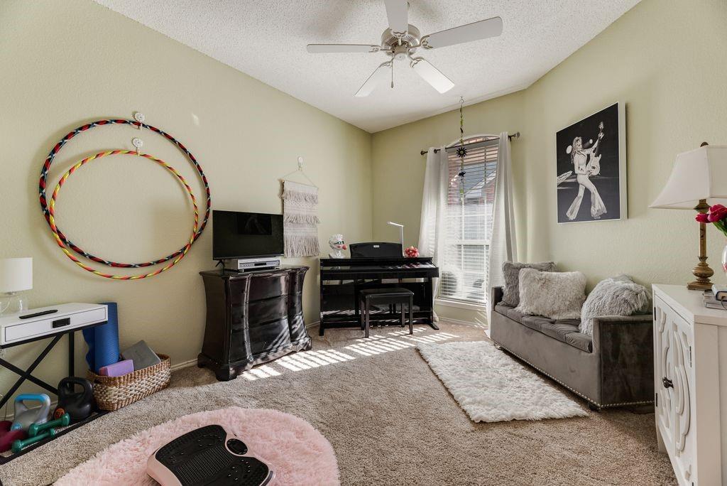 3205 Cape Cod Court Arlington, TX 76017 - Photo 24 of 30 a living room with furniture a fireplace and a flat screen tv