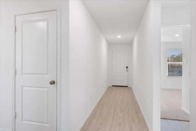 a view of a hallway with wooden floor