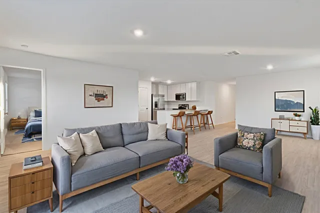 a living room with furniture and kitchen view