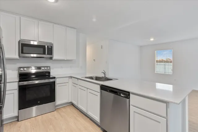 a kitchen with granite countertop a sink and steel appliances