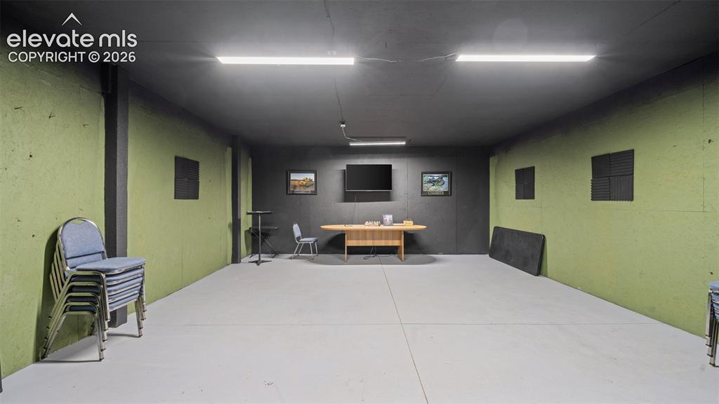 33975 Highway 94 Yoder, CO 80864 - Photo 24 of 40 Spacious room featuring lime green wall panels, a dark gray ceiling, light gray flooring, and multiple rectangular ceiling lights