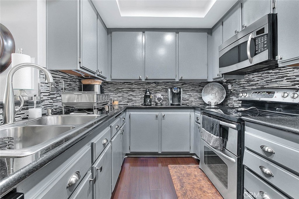44 Carriage Way, Unit 108 Pomona, CA 91766 - Photo 18 of 44 a kitchen with stainless steel appliances granite countertop a sink stove and cabinets
