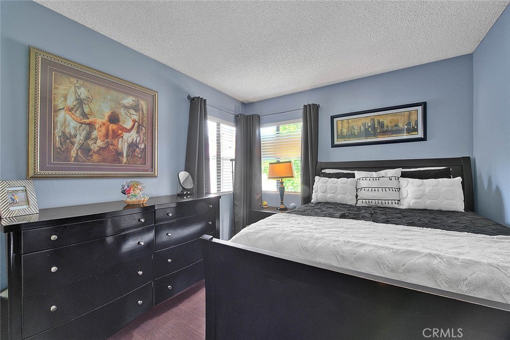 44 Carriage Way, Unit 108 Pomona, CA 91766 - Photo 32 of 44 a bedroom with a bed and a painting on the wall