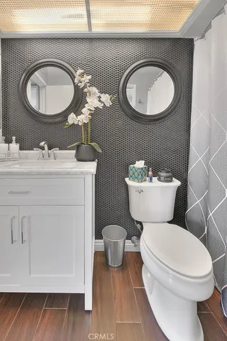 a bathroom with a toilet a sink and a mirror