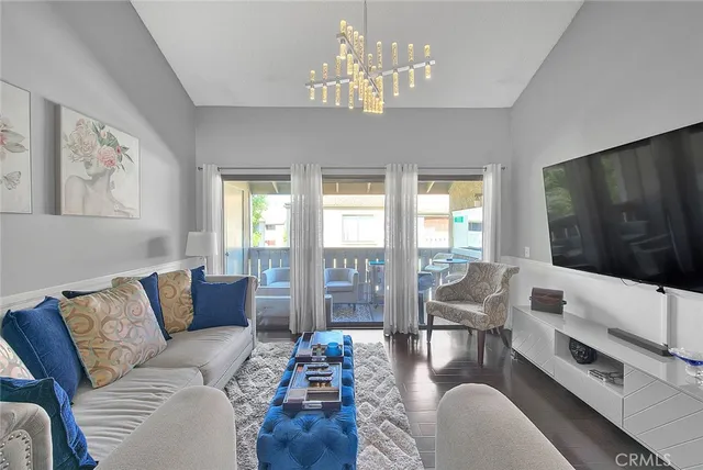 a living room with furniture flat screen tv and large windows