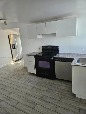 a kitchen with granite countertop a stove and a refrigerator