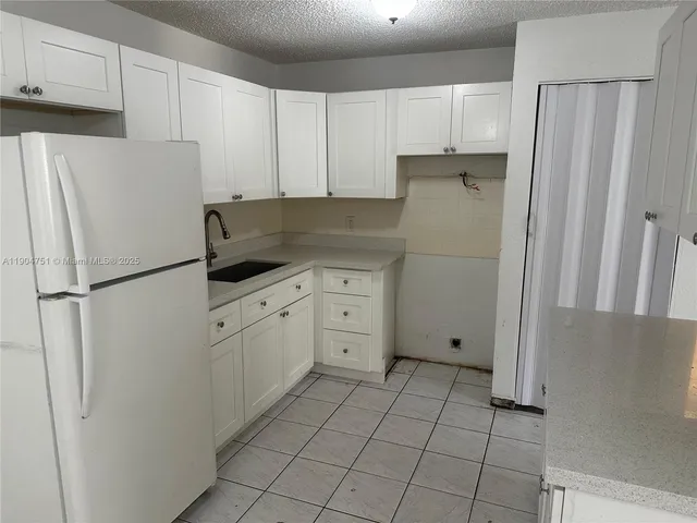 a kitchen with cabinets and refrigerator