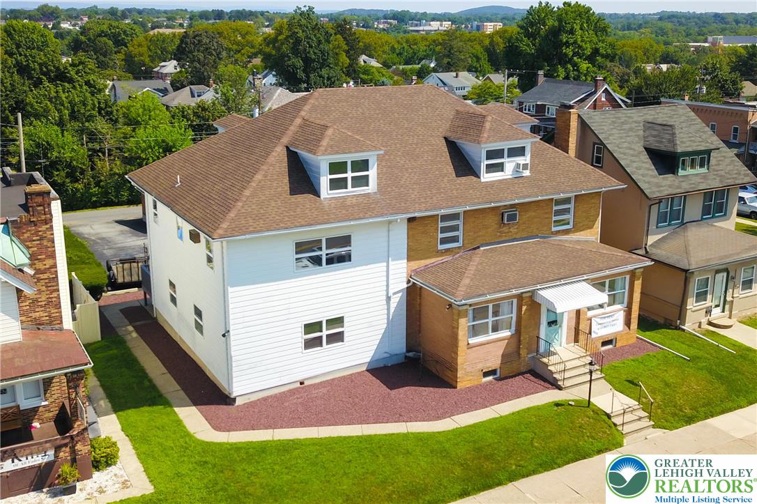 a aerial view of a house with a yard table and chairs