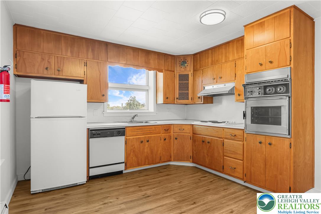 1512 West Broad Street Bethlehem, PA 18018 - Photo 15 of 50 a kitchen with stainless steel appliances granite countertop a refrigerator a sink dishwasher a stove with wooden cabinets and floor