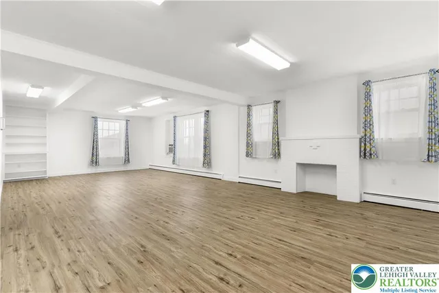 a view of an empty room with wooden floor