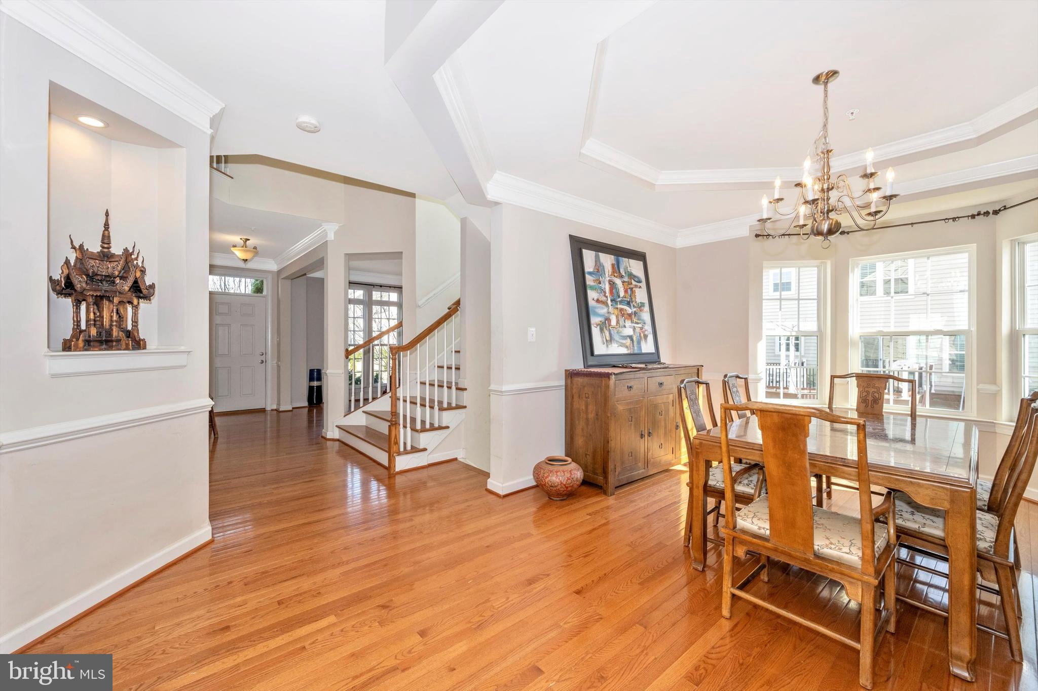 9121 Bealls Farm Road Frederick, MD 21704 - Photo 7 of 63 a dining room with wooden floor a chandelier a wooden table and chairs