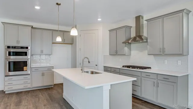a kitchen that has a sink a stove and cabinets