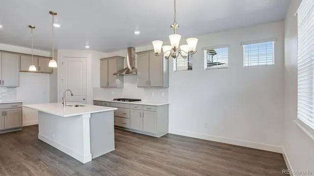 a kitchen with a sink a stove a refrigerator and white cabinets