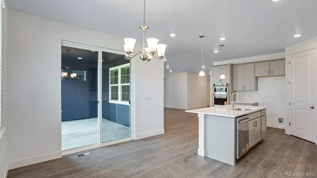 a kitchen that has a lot of cabinets and wooden floor