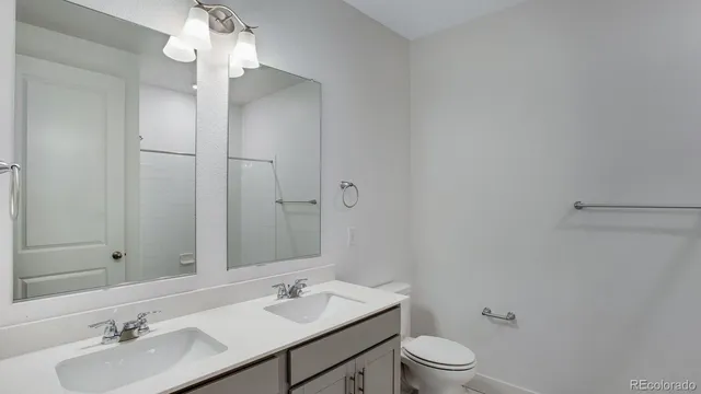 a bathroom with a granite countertop sink toilet a large mirror and shower