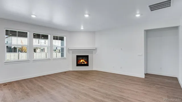 an empty room with wooden floor and fireplace
