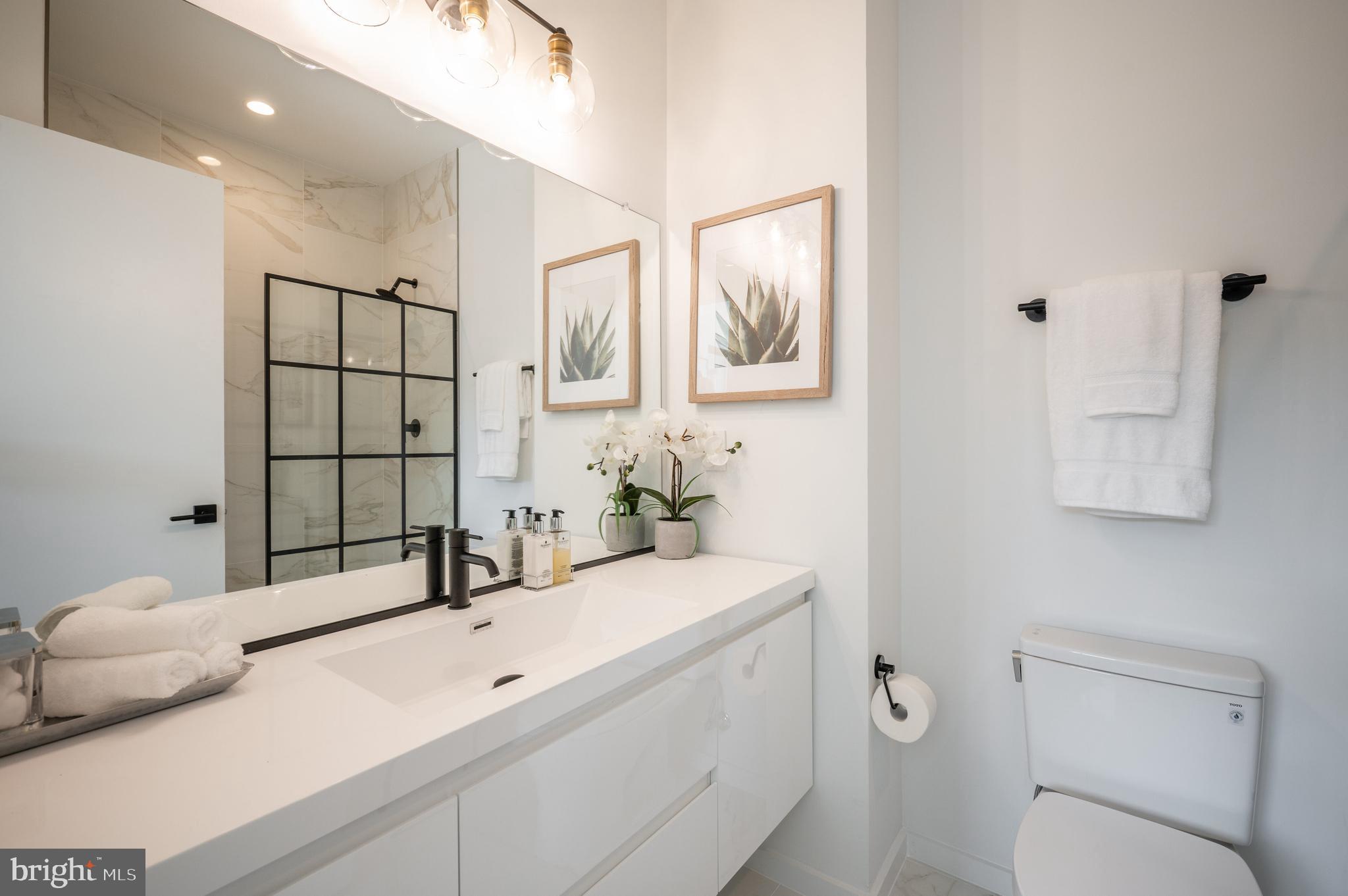 424 M Street Northwest, Unit 8 Washington, DC 20001 - Photo 15 of 27 a bathroom with a sink a toilet and mirror