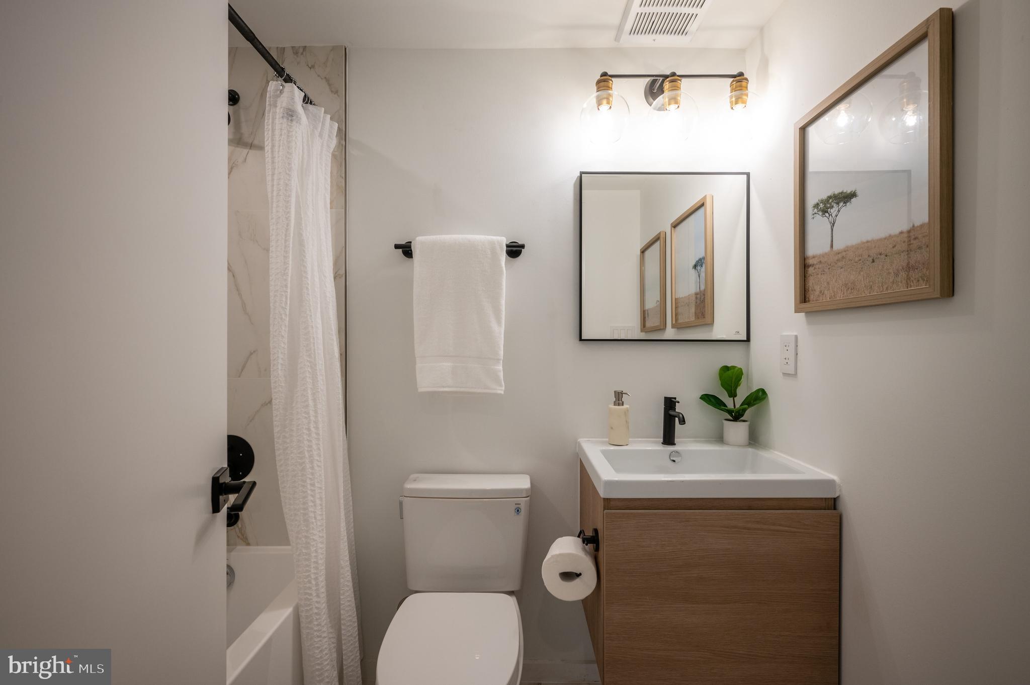 424 M Street Northwest, Unit 8 Washington, DC 20001 - Photo 21 of 27 a bathroom with a toilet a sink and mirror