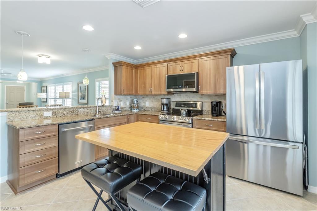 5801 Declaration Court Ave Maria, FL 34142 - Photo 8 of 38 a kitchen with stainless steel appliances granite countertop a refrigerator a stove a sink a center island and a refrigerator