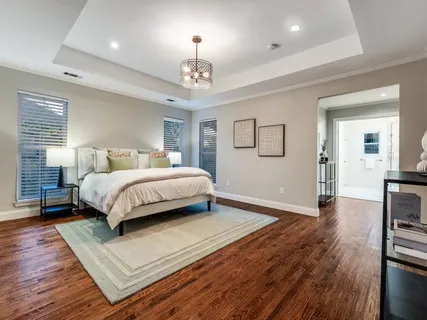 a bedroom with a large bed chandelier and a window