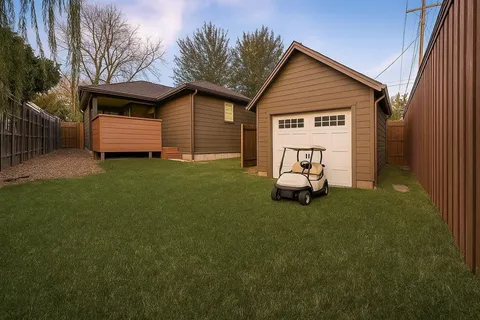 a backyard of a house with wooden fence and barbeque oven