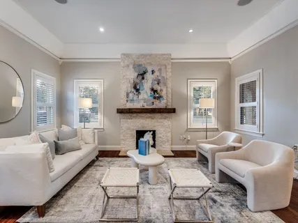 a living room with furniture a fireplace and a large window