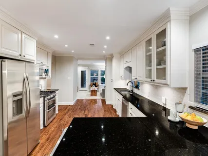 a kitchen with stainless steel appliances a sink stove and cabinets