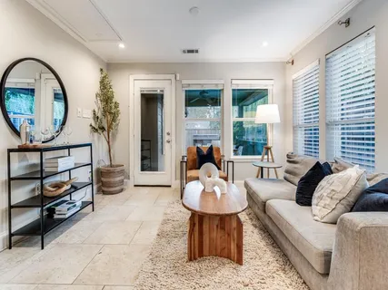 a living room with furniture a window and a potted plant