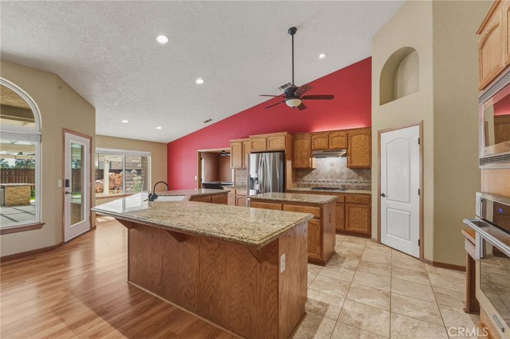 19501 Kinai Road Apple Valley, CA 92307 - Photo 15 of 49 a kitchen with stainless steel appliances granite countertop a kitchen island a stove and a sink
