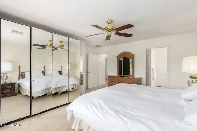 a bedroom with a large bed and a chandelier