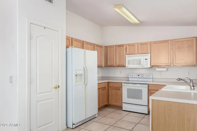 a kitchen with white cabinets and white appliances