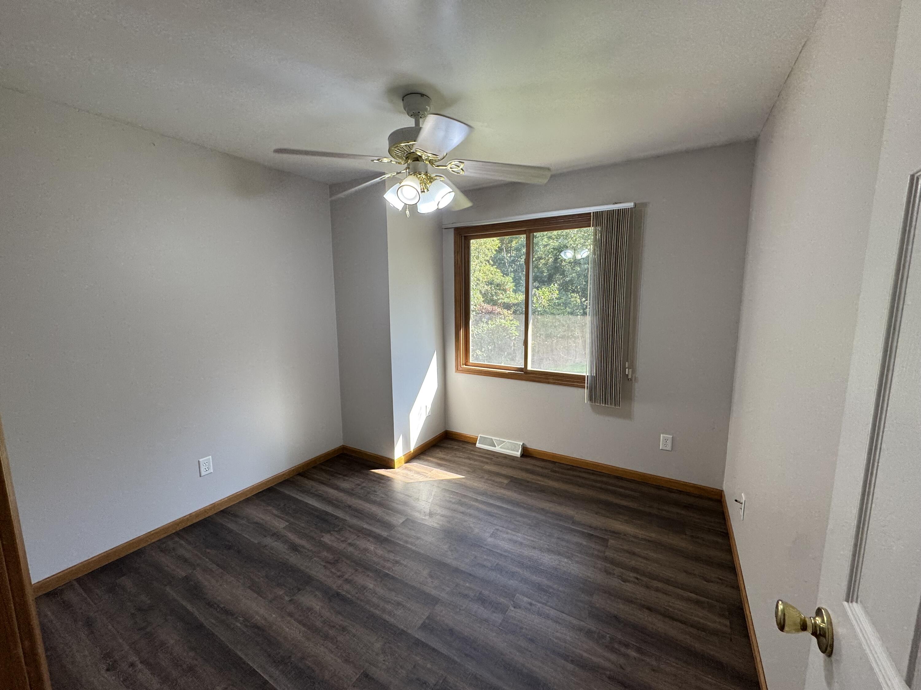 10603 Georgetown Drive Demotte, IN 46310 - Photo 13 of 31 a view of an empty room with wooden floor and a window